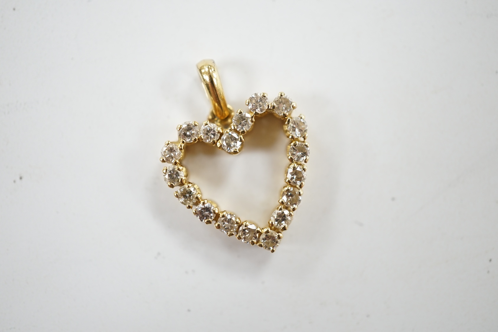 A modern 18k and diamond cluster set open work heart shaped pendant, overall 21mm, gross weight 2.7 grams. Condition - fair to good